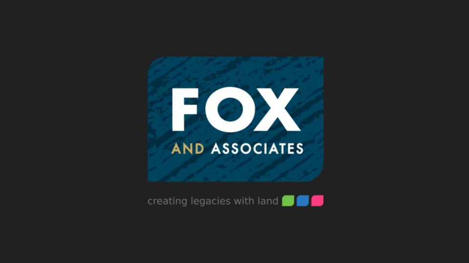 Logo of Fox and Associates, featuring the words 'FOX AND ASSOCIATES' in white and gold against a textured blue background, with the tagline 'creating legacies with land' below in gray.